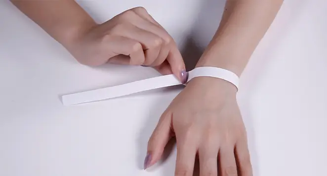 measuring wrist with a paper strip for bracelet size