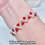 Cross pearl bracelet worn on wrist – red
