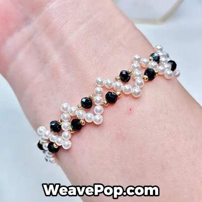 Cross pearl bracelet worn on wrist – black