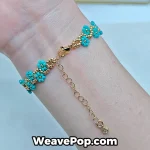 Close-up of a turquoise daisy chain bracelet B077 styled with summer accessories
