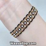 Woman wearing the black and gold geometric interlocking beaded bracelet B081 on wrist, showcasing the glossy black MIYUKI seed bead and gold accent lace design