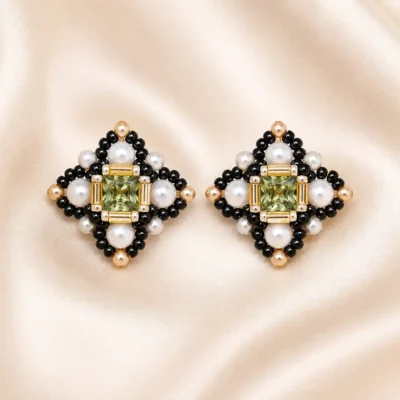 Green crystal pearl cross earring making kit E012 flat lay showing green rhinestone, white crystal pearls, and black and gold Miyuki seed beads on a neutral background